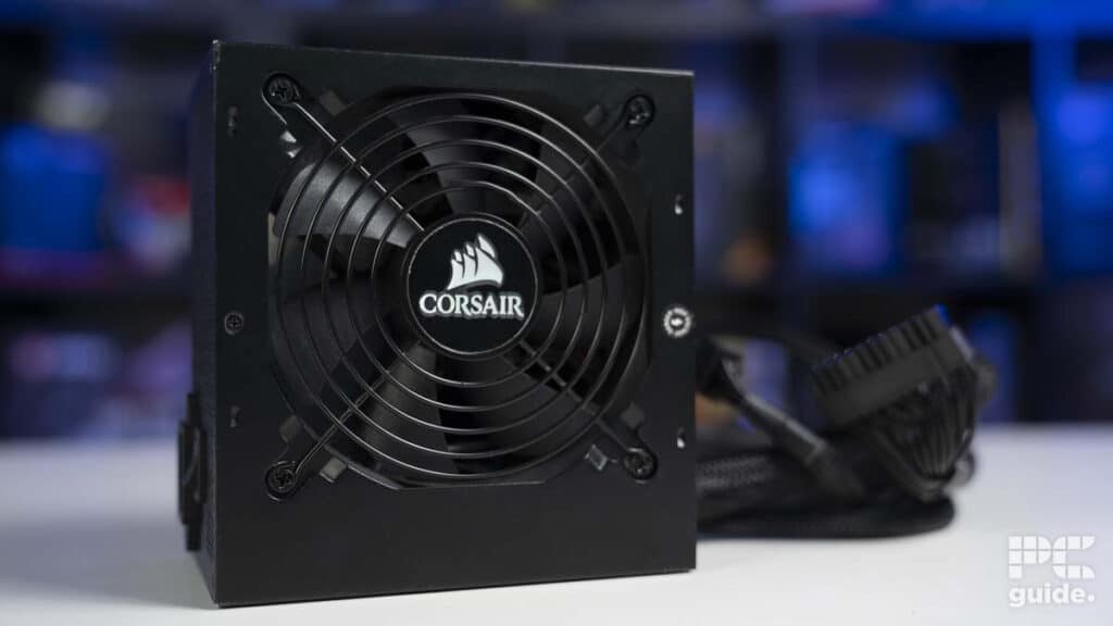 A semi-modular corsair power supply unit with cables on a desk with a blurred background.