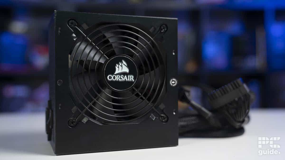 A semi-modular corsair power supply unit with cables on a desk with a blurred background.