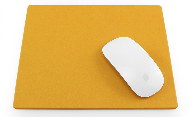 How to clean a mouse pad - a white apple mouse on a clean orange rectangular mouse pad on a white surface.