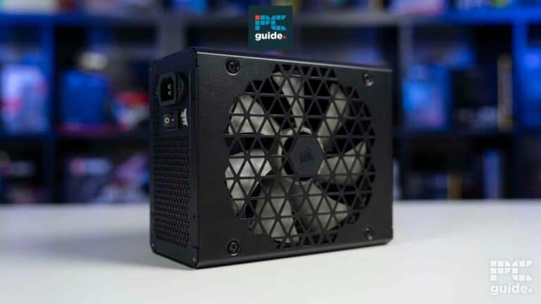 Compact black upgraded external power supply unit for RTX 4000 on a desk with colorful blurred background.