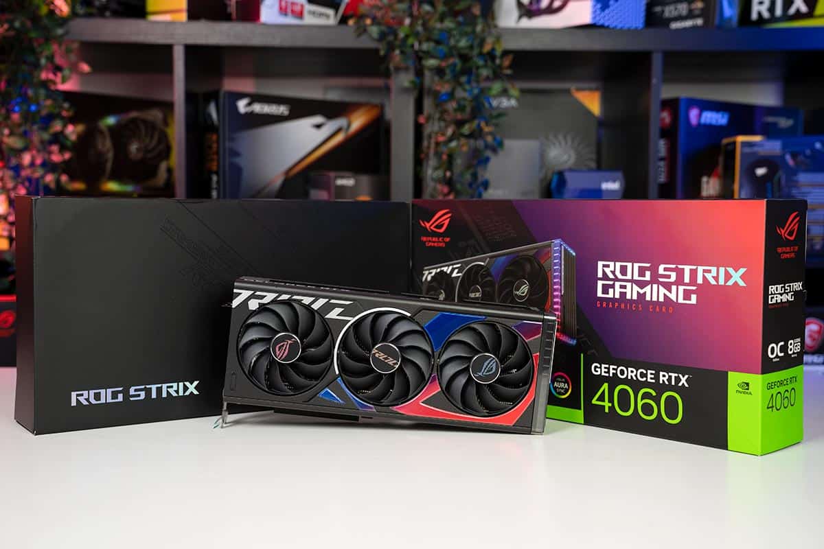 The ASUS ROG Strix Gaming RTX 4060 graphics card is presented in front of its original box, on a white desk.