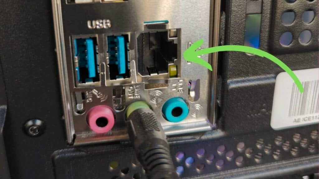 An ethernet cable being plugged into a USB port on a computer's back panel.