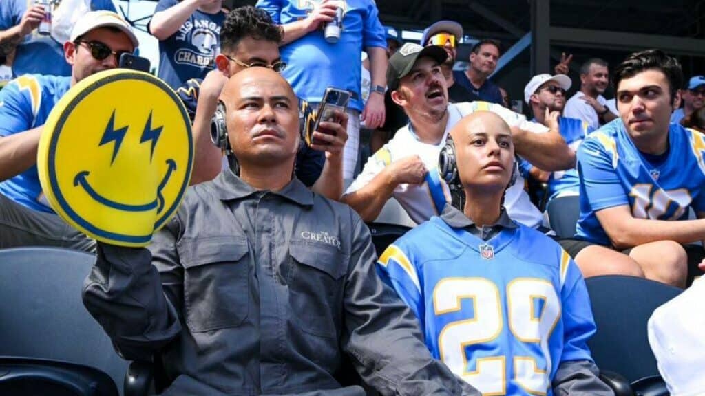 Los Angeles Chargers fans hold up a smiley face sign during an AI-driven game.