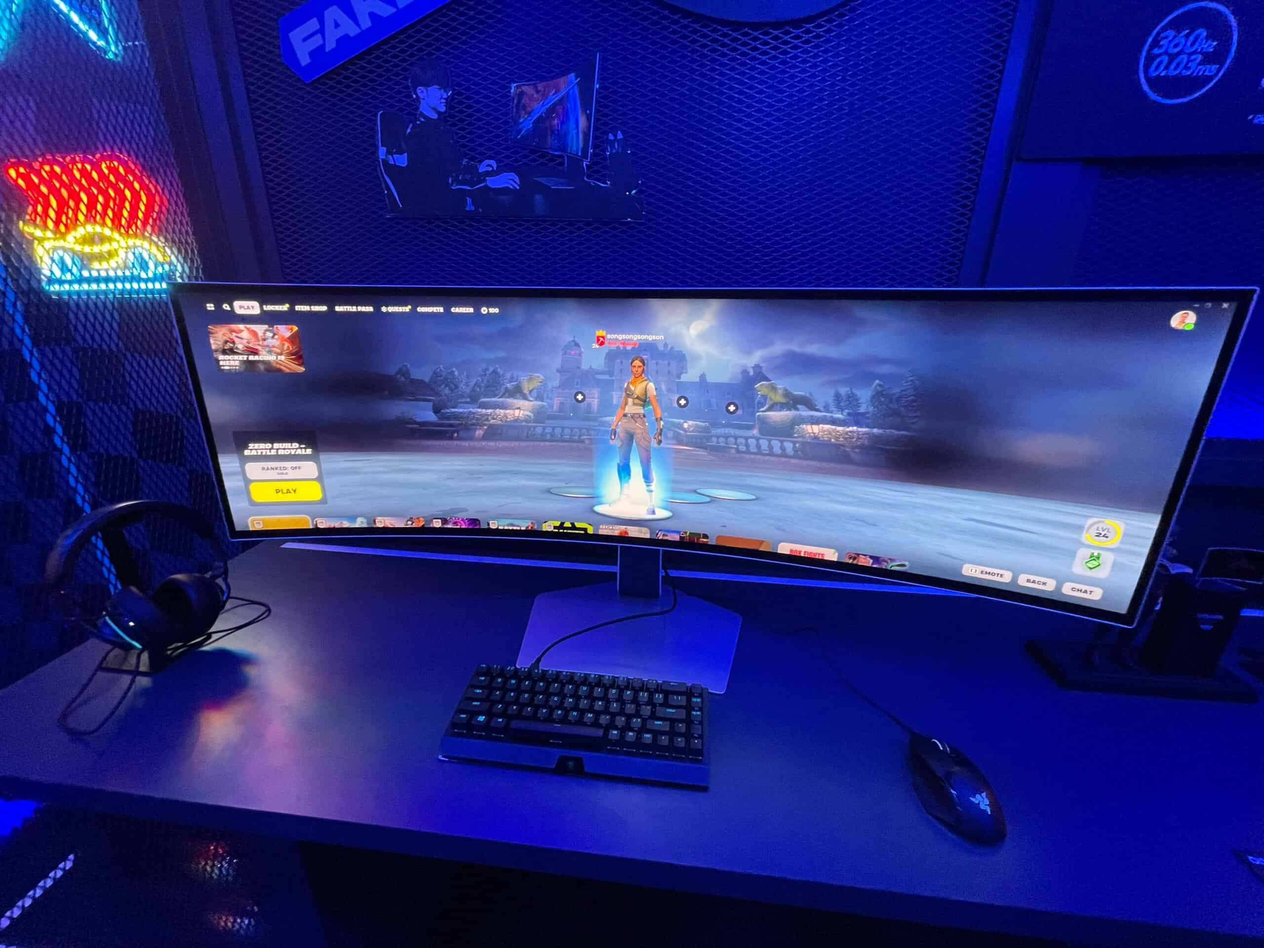 A computer monitor with a keyboard and mouse on a desk, rumored to be the upcoming Samsung Odyssey G9 OLED.