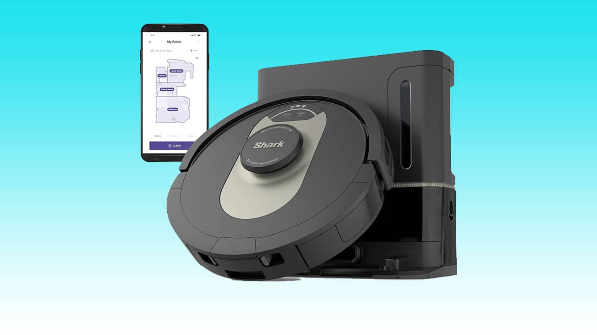 A smart phone sits next to an Auto Draft robotic vacuum cleaner.