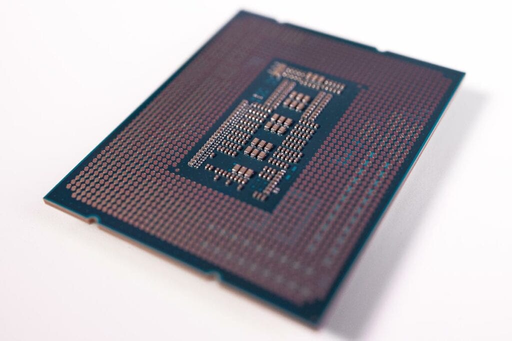 Close-up of an Intel Core i9-13900K CPU with visible contact pins against a white background.
