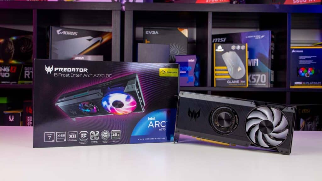 A review of the Predator Bifrost Intel Arc A770 graphics card, alongside its packaging on a desk with computer hardware shelves in the background, explores whether it's worth it.