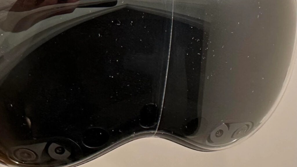 A close up of a black motorcycle helmet with some minor cracks.