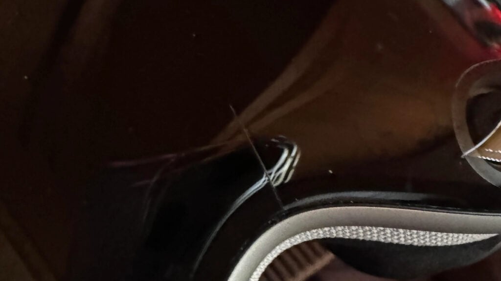 A close up of a black guitar with no cracks.