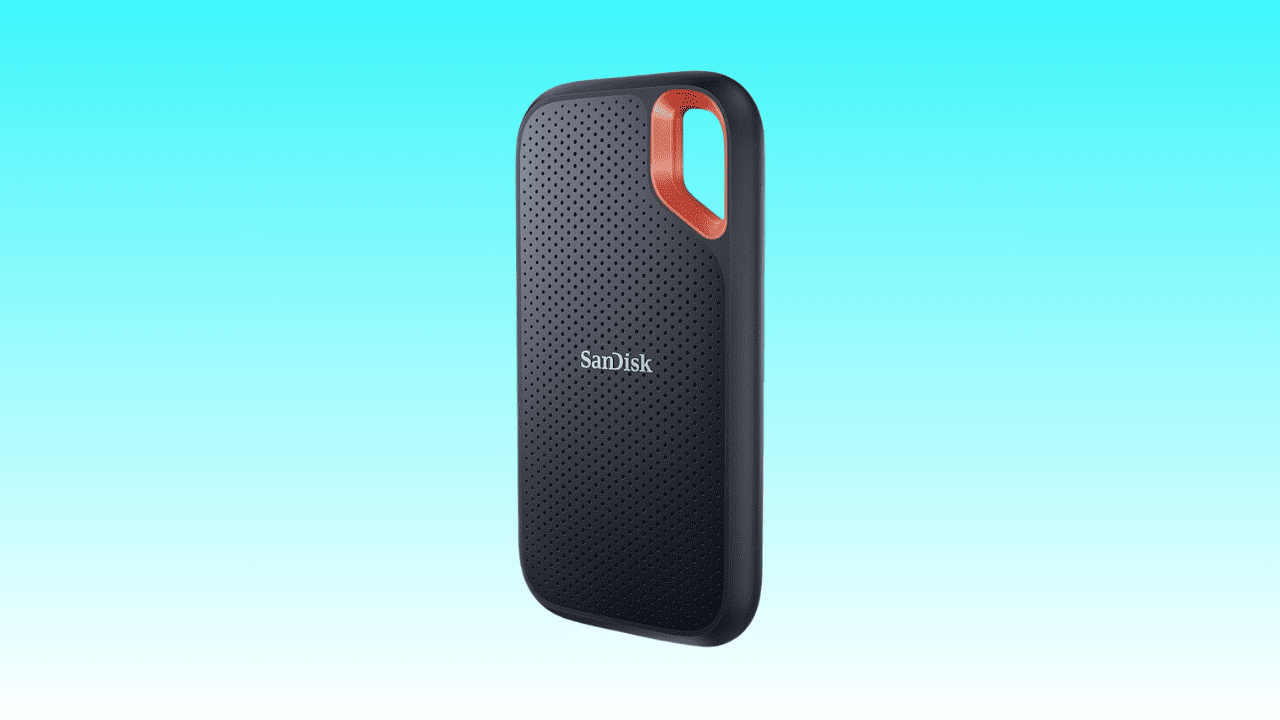 SanDisk Portable SSD with a black textured design and orange loop on a blue background, now available at a reduced price thanks to an Amazon deal.