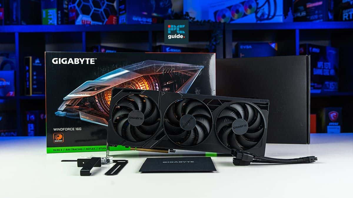 A Gigabyte GeForce RTX 4080 Super graphics card with its box and accessories displayed on a desk with colorful LED lighting in the background.