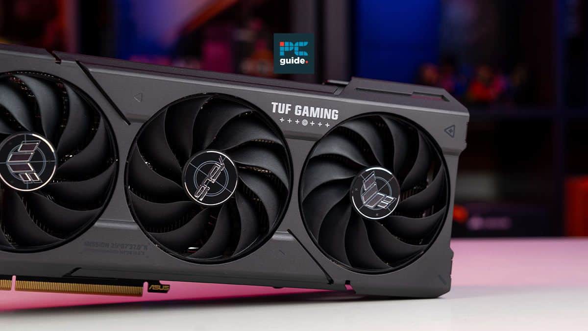 Asus TUF gaming graphics card with triple fan design, placed against a blurred background.
