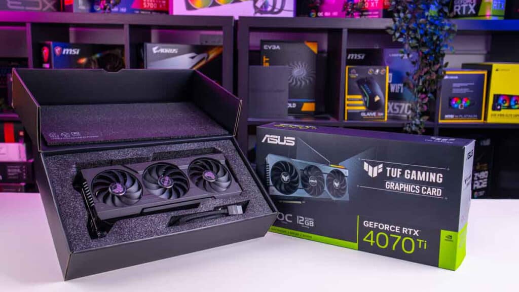An Asus TUF Gaming Nvidia RTX 4070 Ti graphics card and its packaging displayed on a desk with various computer parts in the background, showcasing why it's considered worth it in many a review