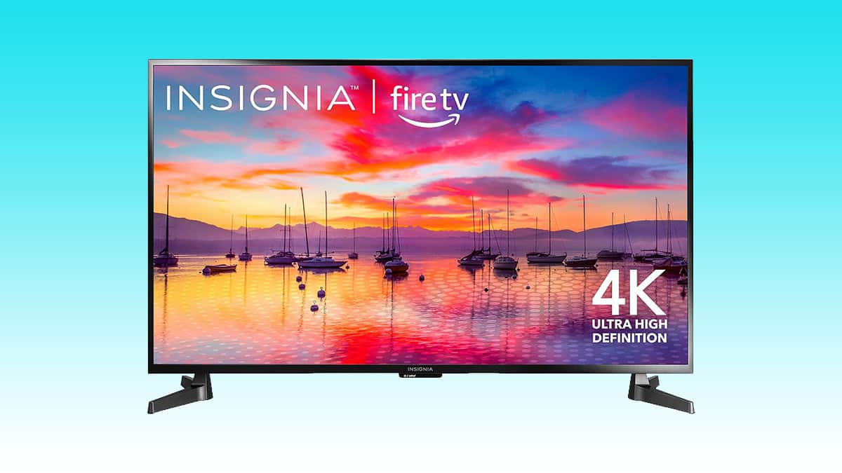 An insignia 43" 4K LED Fire TV displaying a colorful sunset with boats on water.