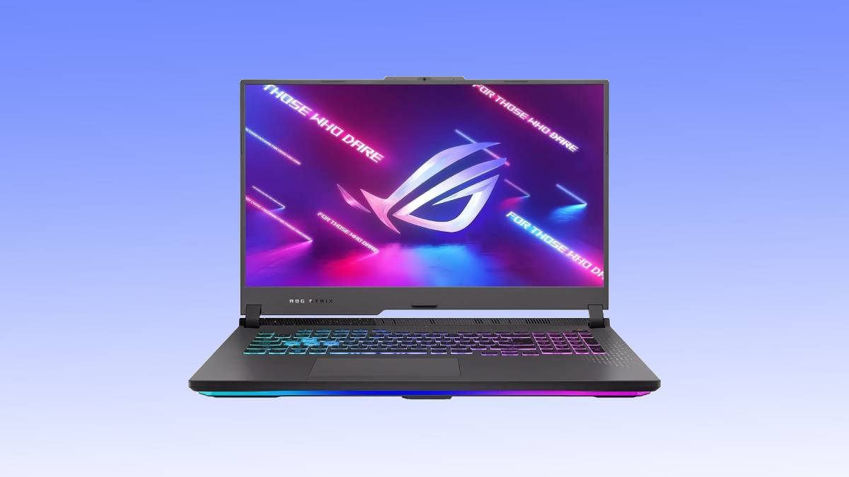 A gaming laptop deal with an illuminated keyboard and a colorful Asus ROG wallpaper displayed on the screen, set against a plain blue background.
