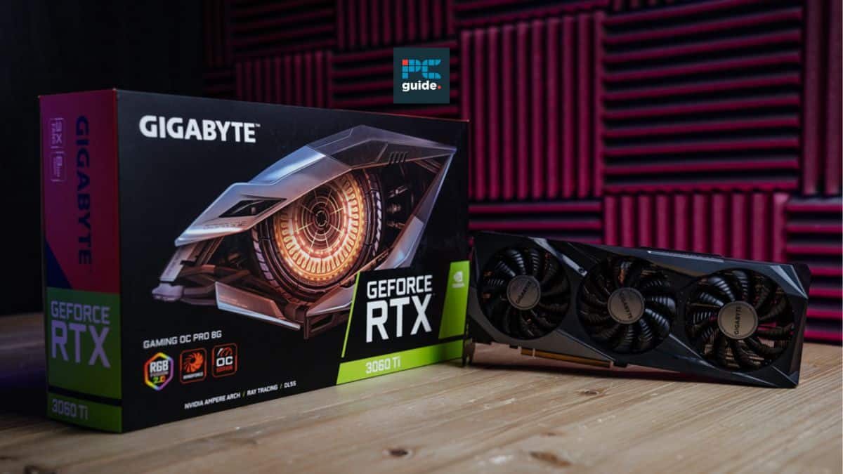 A gigabyte geforce rtx 3060 ti graphics card and its box displayed on a wooden table against a red foam panel background, ideal for pairing with the best CPU for RTX 306