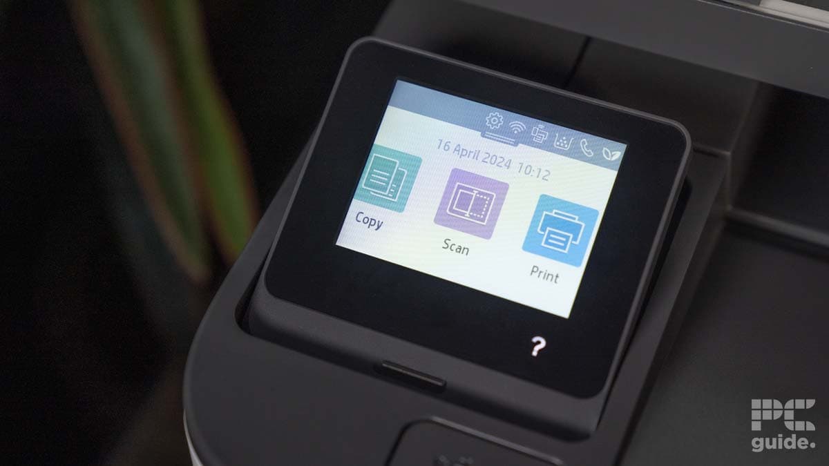 Close-up of an HP LaserJet Pro MFP 3102fdwe's lcd touchscreen displaying options for copy, scan, and print with the date and time at the top.