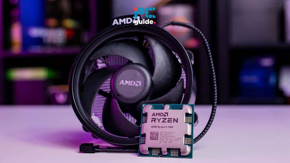 An AMD Ryzen CPU placed in front of its cooling fan on a desk, displaying a "CPU fan error" message, with a blurred background featuring colorful computer hardware.