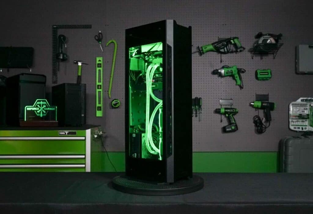A custom-built pc with green lighting inside a transparent case, displayed on a workbench in a workshop with tools hanging on the wall.