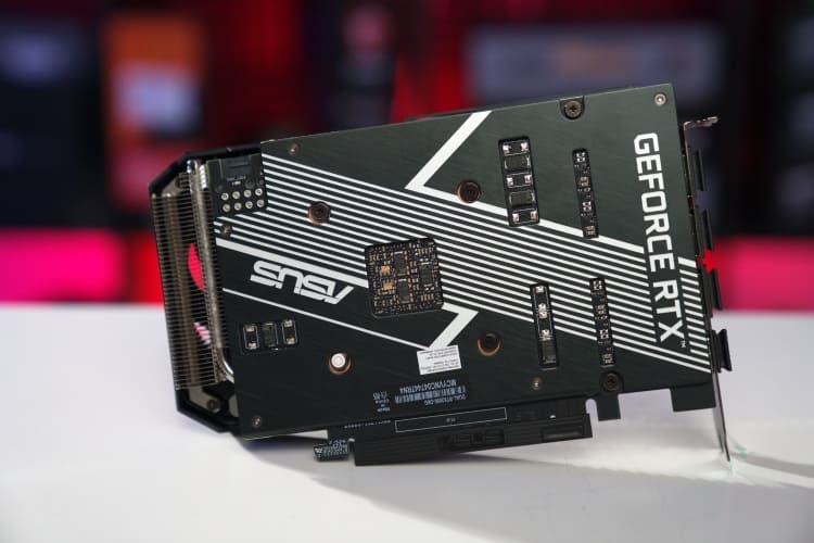 An Asus GeForce RTX 3050 graphics card displayed against a blurred red and black background.