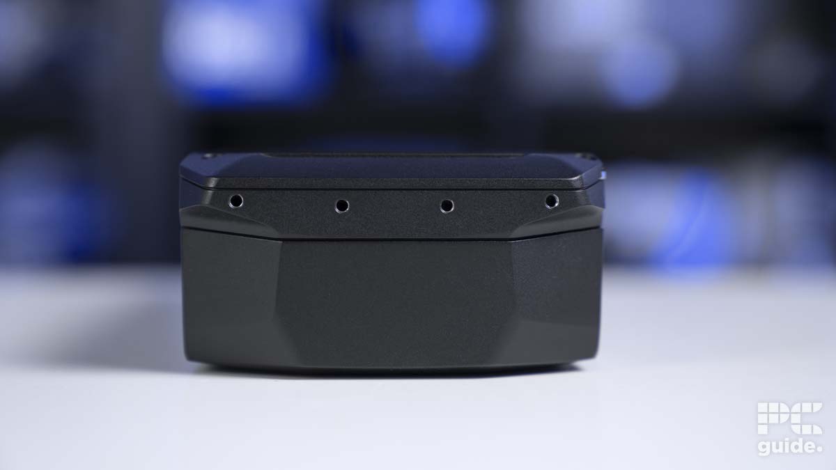 Black electronic device with LED indicators, highlighting the review of AMD Radeon RX 7800 XT, on a white surface with a blurred background.