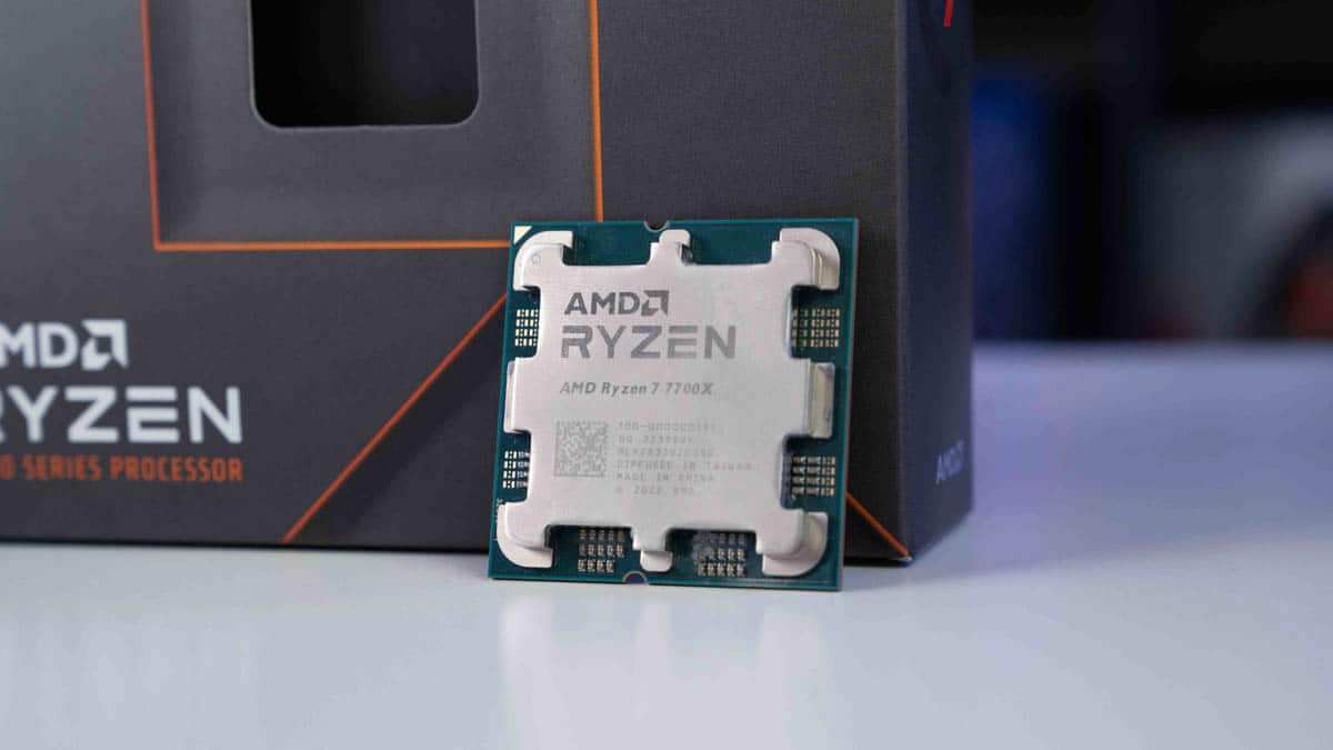 Two AMD Ryzen 7 7700X processors in front of their packaging, clear and focused against a blurred background, ready for review.