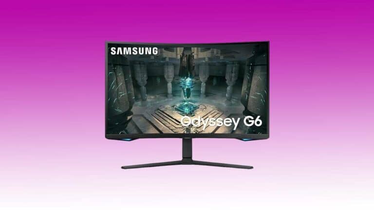 A Samsung Odyssey G65B curved gaming monitor displaying a fantasy video game scene with an illuminated blue crystal in a dark, ancient chamber.