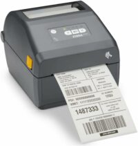 A Zebra ZD421 barcode printer with a partial roll of printed shipping labels emerging from its slot.