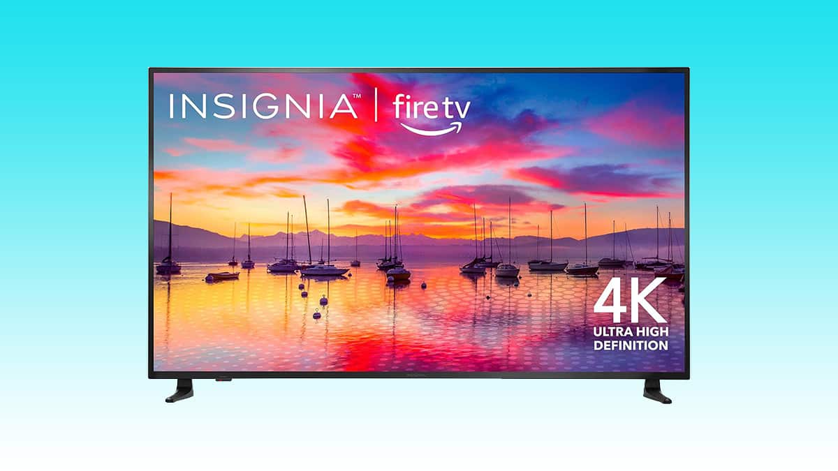 Insignia branded 65" 4K Fire TV at its lowest-ever price, displaying a vibrant sunset scene over a marina with boats.