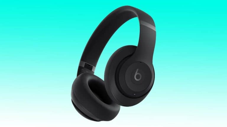 Black Beats Studio Pro Headphones with a prominent logo on a gradient blue and teal background.