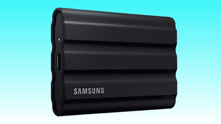 Black Samsung T7 Shield portable SSD with a ribbed design, displayed against a teal background.