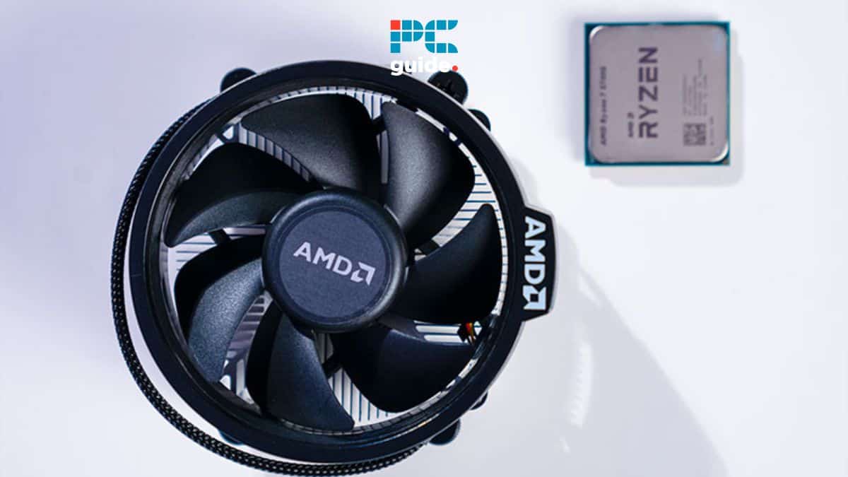 An AMD Ryzen CPU next to an adjustable black AMD cooling fan on a white surface.