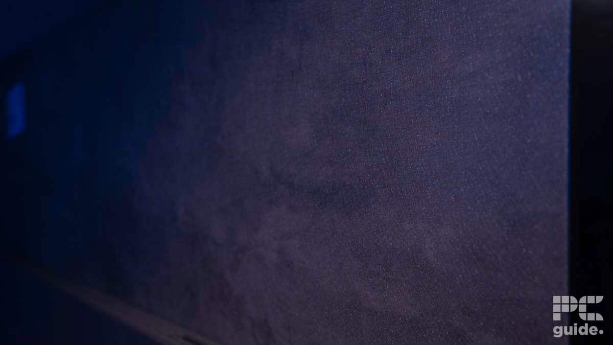 Close-up view of a dark textured surface, possibly an electronic device or panel, with the 