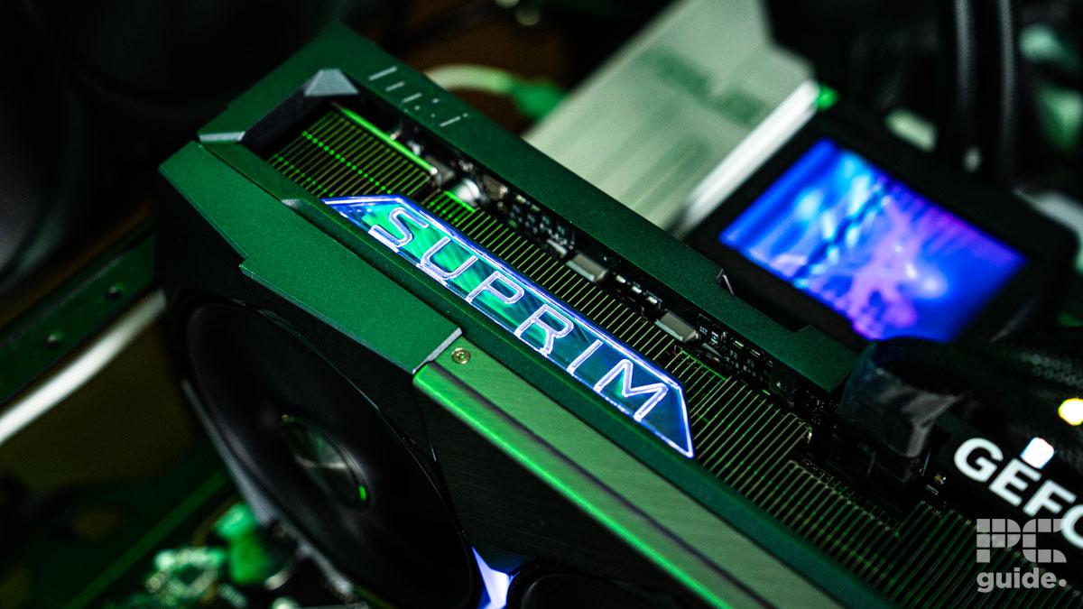 The MSI Suprim SOC RTX 5090 installed on a motherboard. It's a close up of the edge with the logo SUPRIM that is lit up with a white LED.