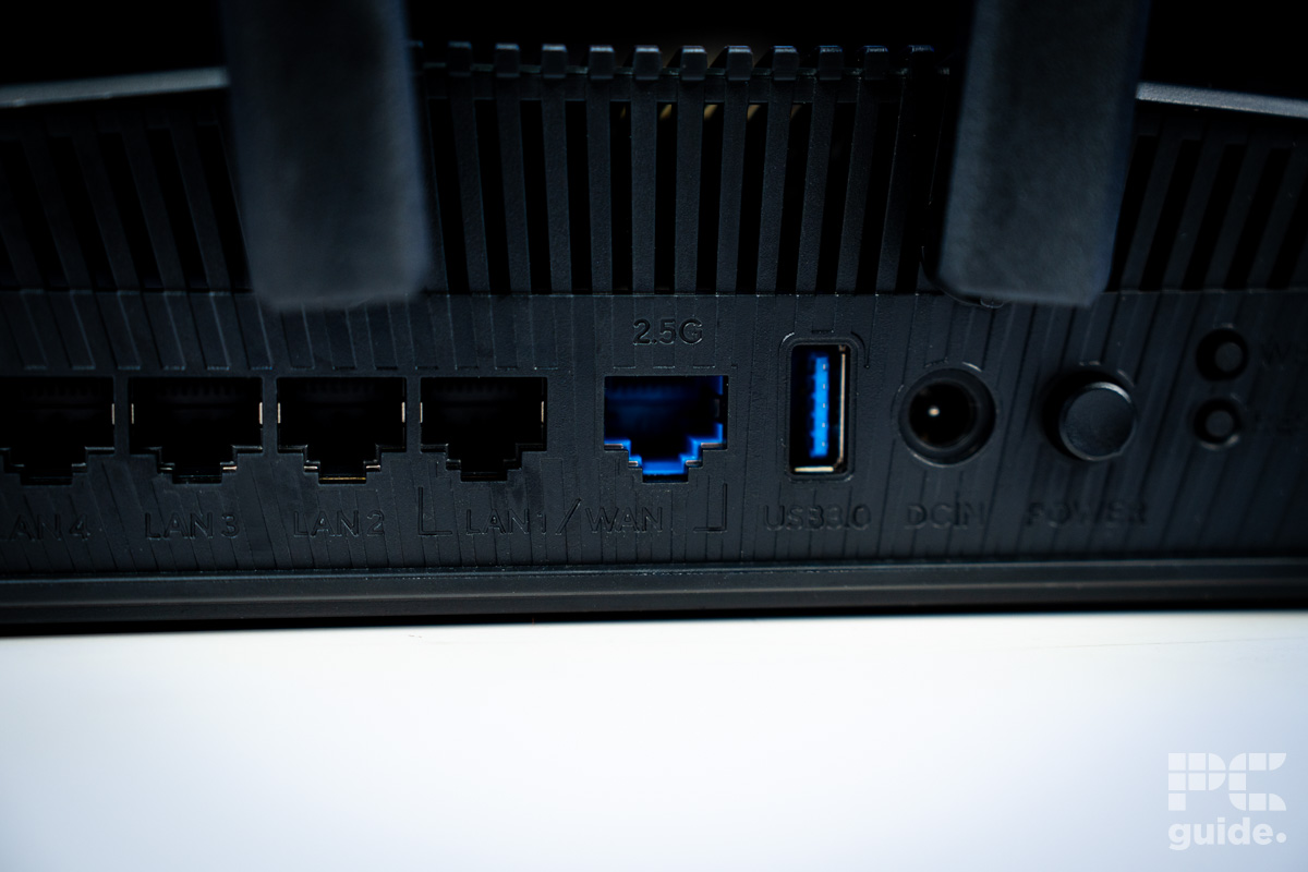 The back of the ASUS RT BE58U router showing all four RJ45 ports, a USB, barrel jack and three buttons.