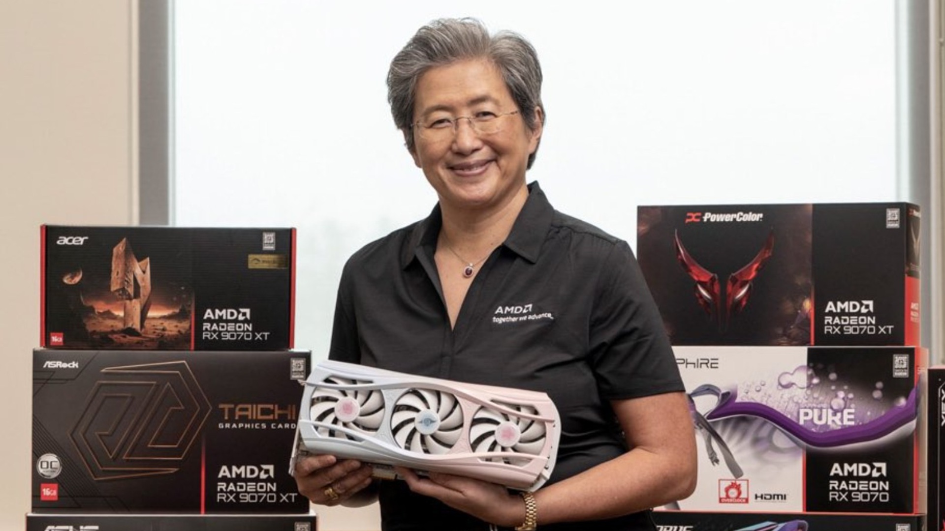 AMD CEO Lisa Su holding RX 9070 XT graphics card, source: AMD