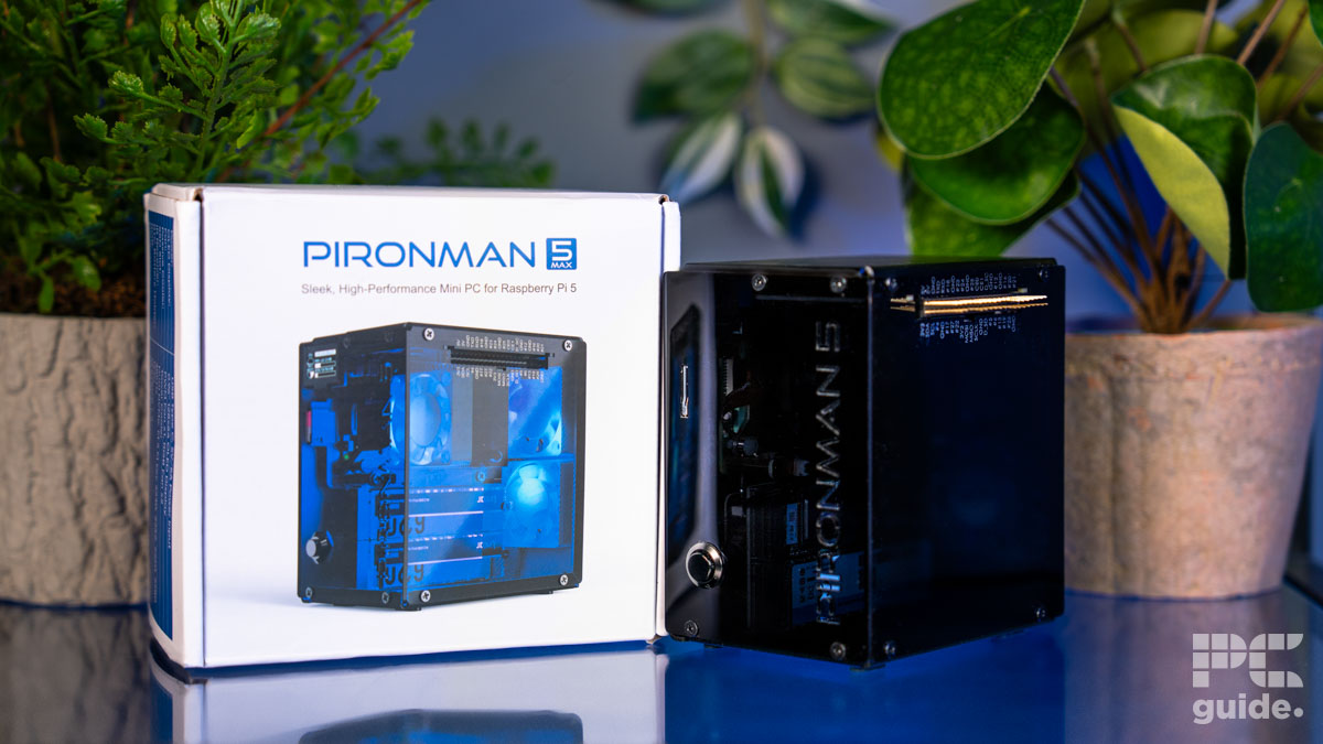 A white box case on the left that reads PIRONMAN 5 max with itt shown below. On the right is the case built itself. They sit on a blue table and have flower pots on either side behind.