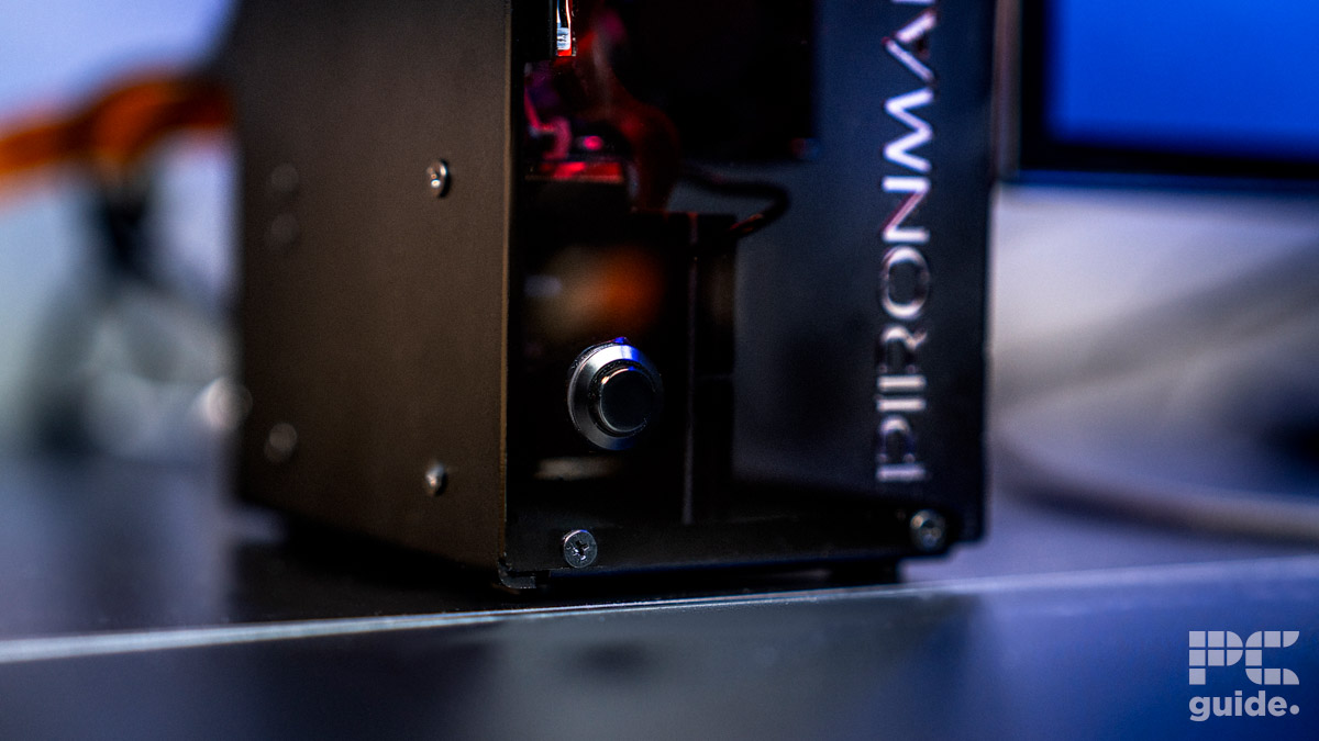 The Pironman 5 Max case fron showing off the push button in the bottom left. Withe the left side shows crews and on the right is the start of the case model travelling up the panel.