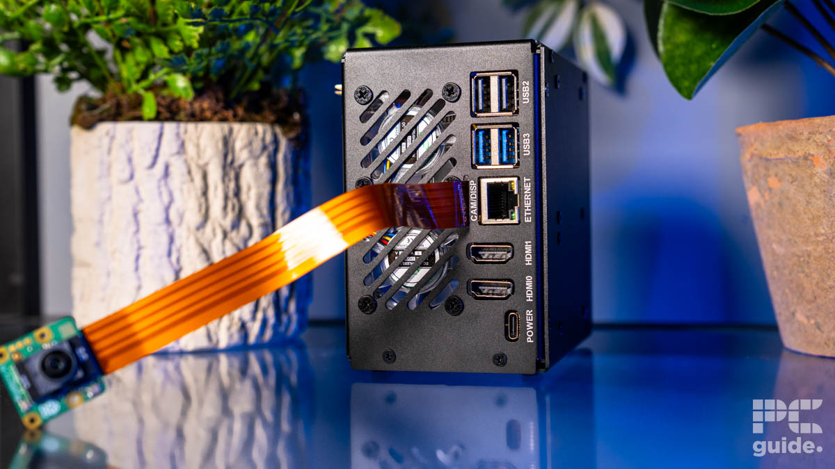 The rear of the Pironman 5 Max case. It shows the two USB2, two USB 3, one Ethernet, two HDMI, and one power port. There is also a slot for the cam/disp cable and vent for the two fans.