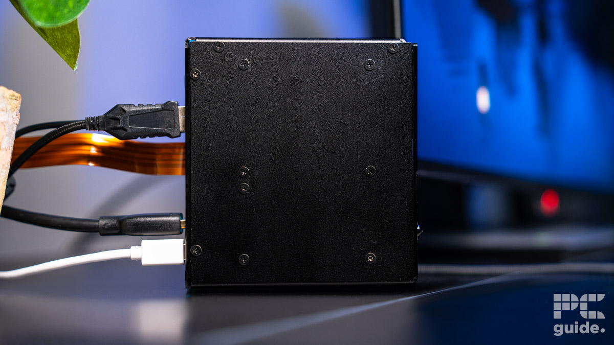 Left side panel of the Pironman 5 Max case. It shows the screws holding it all in place and cables coming out of the rear.