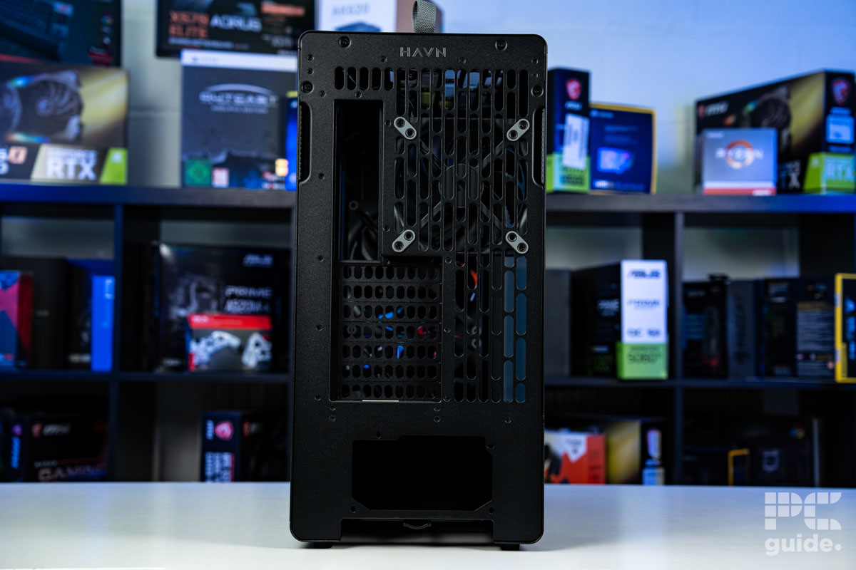 The rear of the HAVN BF 360 Flow standing on a white table and a blurred bookshelf of PC component boxes in the background.