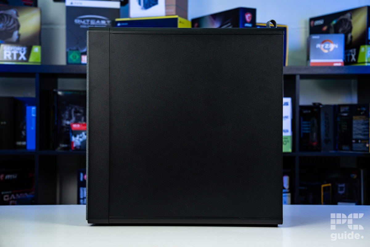 Left side of the HAVN BF 360 Flow case with the panel on. It stands of a white table with PC component boxes on a bookshelf in the background.