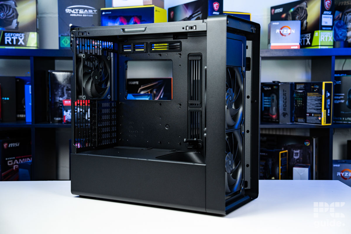 The HAVN BF 360 Flowcase from teh right side at an angle with its panels off. It sits on a whte tabvle with a background of PC component boxes on a bookshelf.