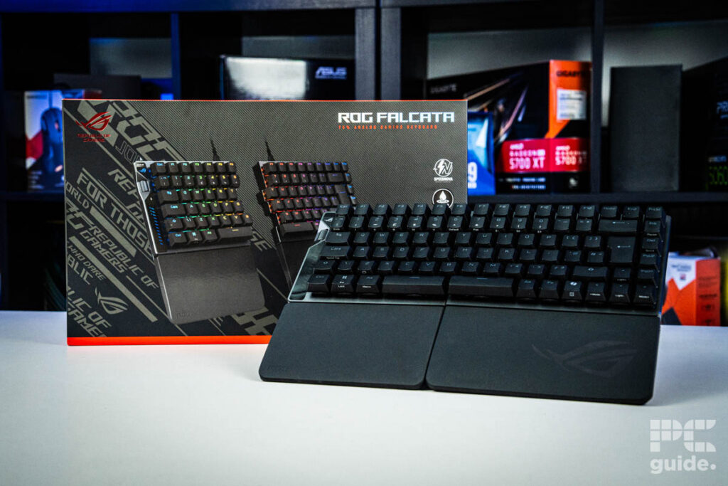 ROG Falcata leaning against its box on a white table with a background of PC components on a bookshelf.