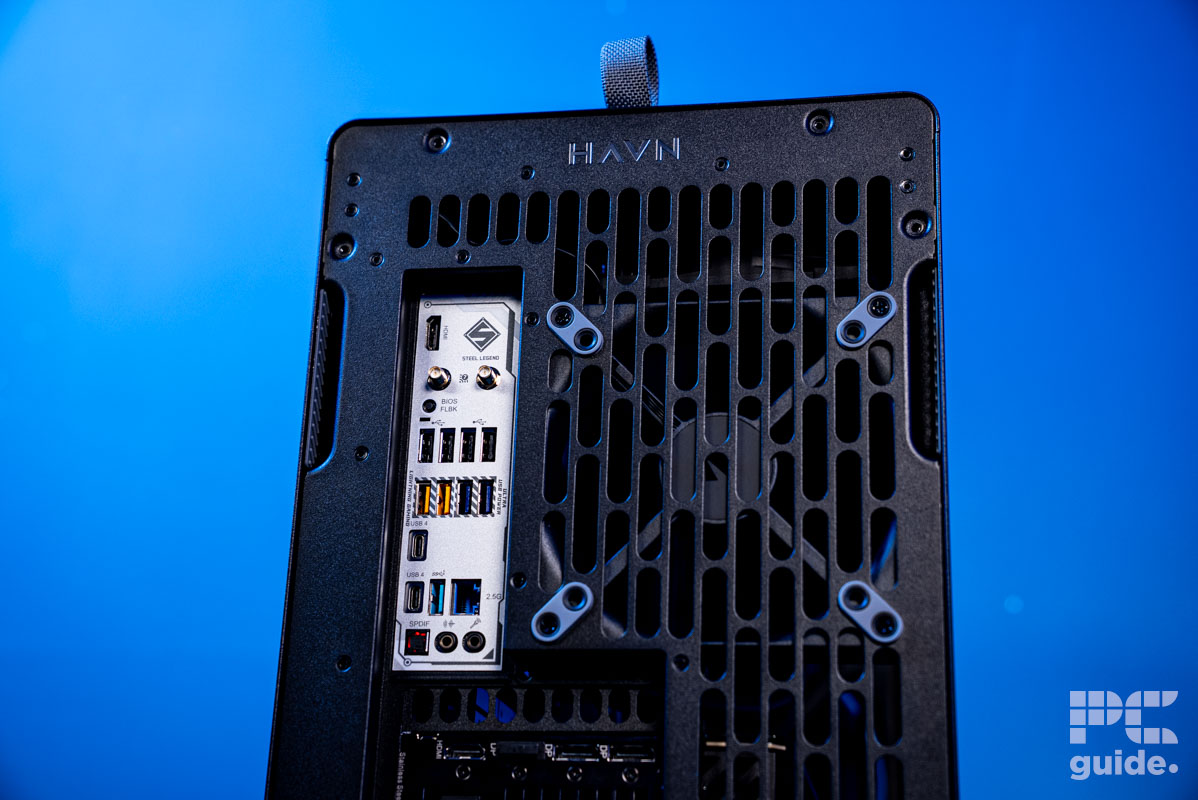 The top half of the rear of the HAVN BF 360 Flow case with a white IO motherboard and fan next to it.