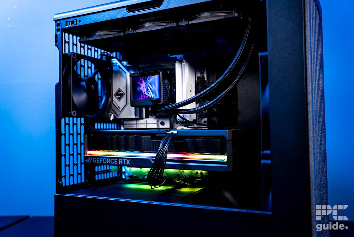 The inside of the HAVN BF 360 Flow case featuring a GPU, motherboard, AIO, and back fan. The background is a blue wall.