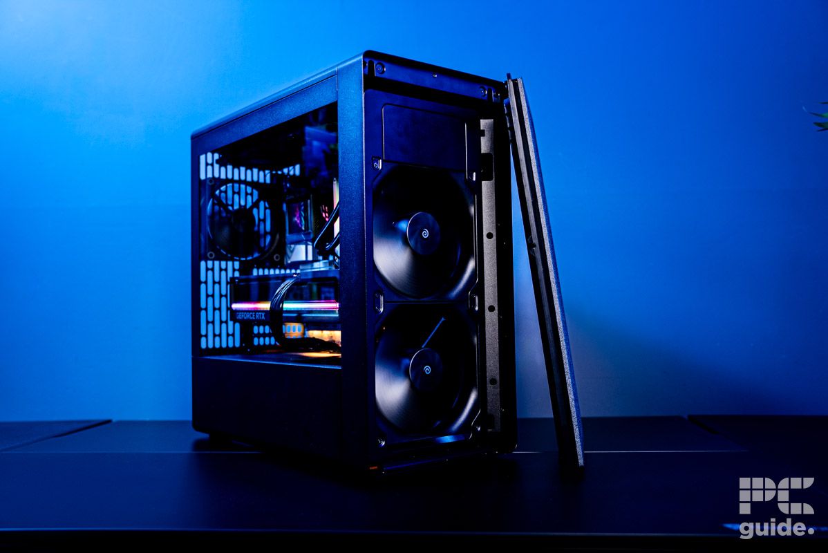 The front of teh HAVN BF 360 Flow case with the grill taken off showing the two 180mm fans spinning. Sitting on a table with a blue wall.